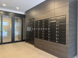クラリティア上野稲荷町 モダンな共用エントランスホール、壁面に整然と並ぶメールボック
