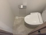 クラリティア上野稲荷町 温白色照明で落ち着いた雰囲気のトイレ室内、タンクレストイレ設