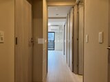 クラリティア上野稲荷町 明るい色調の廊下に複数のドアが並ぶ居住空間