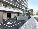 パークアクシス住吉ガーデンスクエア 身障者駐車スペースを備えた開放的な駐車場と建物外観