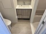 パークアクシス住吉ガーデンスクエア 洗面台と便器が配置された落ち着いた色合いの洗面トイレ空間