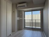 パークアクシス住吉ガーデンスクエア 光が差し込む居室とバルコニーへのガラス戸が見える明るい室内