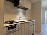パークアクシス住吉ガーデンスクエア 木目調のキッチン収納とステンレス製調理機器が備わった開放的な