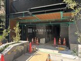 ザ・パークハビオSOHO新宿御苑 建設中のエントランス周辺、緑色の仮囲いと木製庇が設置された様