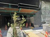 ザ・パークハビオSOHO新宿御苑 建設中の物件の大きなガラス窓とモダンな木製天井が特徴のエント