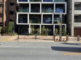 ES-Grande錦糸町ザ・クラス 前面道路から見たモダンな建物外観と植栽のある入り口