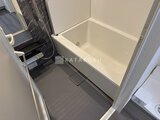 ES-Grande錦糸町ザ・クラス 白いバスタブと暗色タイルの床を備えたシャワールーム