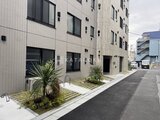 ES-Grande門前仲町デュオ モダンなタイル張りの外観と植栽が調和した建物エントランス