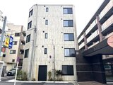 ES-Grande門前仲町デュオ 落ち着いた色合いの縦長ファサードを持つ5階建て建物の前面道路