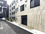 ES-Grande門前仲町デュオ 木目調タイルの外壁が印象的な建物の駐車場からのアプローチ