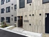ES-Grande門前仲町デュオ 木調パネルと白タイル貼りのモダンな建物外観