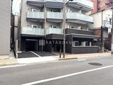 ES-Grande門前仲町 前面道路から見た、モダンな印象の建物外観と駐車場の様子