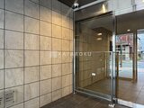 ES-Grande門前仲町 モダンなタイル張りの壁と透明ガラスドアが映るエントランスホー