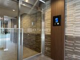ES-Grande門前仲町 エレベーターホール入口、木調タイルとガラスで統一した落ち着き