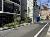 プライムブリス森下スタジオ 建物入口から見た開放的なアプローチと緑が映える外観