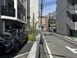 プライムブリス森下スタジオ 駐車場から見た建物エントランスと周辺の開放的な街並み