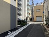 プライムブリス森下スタジオ 駐車スペースと植栽のあるモダンな外観エントランス
