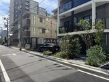 プライムブリス森下スタジオ 前面道路から見た建物外観と植栽が配置された駐車スペース