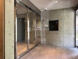 プライムブリス森下スタジオ 洋風のタイル張り壁と木目調床が落ち着いた共用通路