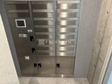 プライムブリス森下スタジオ 玄関脇に設置された複数の宅配ボックスと集合住宅用インターホン