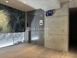 プライムブリス森下スタジオ エレベーターホール、大理石調の壁面と木目床の落ち着いた空間
