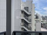 プライムブリス森下スタジオ 隣接する建物の外壁と階段状のバルコニーが見える眺望