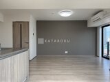 プライムブリス森下スタジオ 明るい床色とグレー壁が調和したリビングダイニング空間