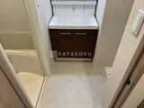 プライムブリス森下スタジオ 白いボウル型洗面台と濃木目のキャビネットが備わった洗面室