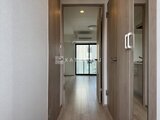 プライムブリス森下スタジオ 廊下から居室へと続く開放的な空間にモダンな木調ドアが並ぶ様子