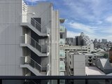 プライムブリス森下スタジオ バルコニーから見た建物外観と都市風景