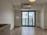 プライムブリス森下スタジオ 明るい印象のリビングから街並みを望むバルコニー付き洋室