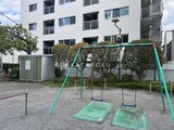 ブランシエスタ品川大井町パークエッジ 建物前のオープンな空間に設置された遊具とベンチ付きの共用庭