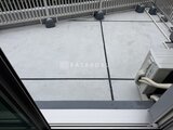 ブランシエスタ品川大井町パークエッジ バルコニーの広い床面と白いフェンス、屋上設備が見える様子