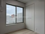 ブランシエスタ品川大井町パークエッジ 街の眺めが広がる窓と白基調の収納が備わったモダンな洋室