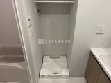 ブランシエスタ品川大井町パークエッジ 洗濯機置きスペースと白を基調とした浴室の様子