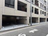ドゥーエ銀座イースト3 白を基調とした建物のゆとりのある駐車場入口の様子