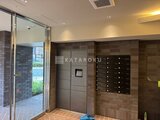 デュオフラッツ浅草田原町ネスト 茶色のタイル壁と郵便受けが設置されたエントランスホール