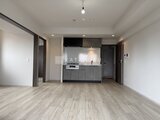 デュオフラッツ浅草田原町ネスト グレー基調のシステムキッチンと開放的なリビングダイニング空間