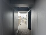 アーバネックス住吉 高層階からの眺望が望めるモダンなバルコニーへと繋がる廊下