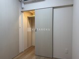アーバネックス住吉 白を基調とした廊下から洋室へ続く開き戸と明るい空間