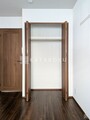 ザ品川イーストレジデンス 開き戸のクローゼットと落ち着いた色合いの洋室の様子