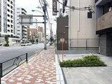 ドゥーエ両国5 前面道路から見た建物エントランスと落ち着いた印象の街並み