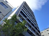 ザ・パークハビオSOHO高田馬場テラス 下から見上げた落ち着いた色合いのマンション外観と青空