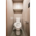 ザ・レジデンス用賀 温かみのあるトーンでまとめたトイレ空間と上部の収納棚