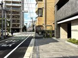 デュオメゾン品川戸越 前面道路から見た建物エントランスと周辺街並み