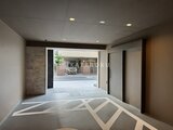 デュオメゾン品川戸越 開放的なエントランスホールから外部の共用庭を見通す様子