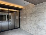 デュオメゾン品川戸越 大理石調のタイル壁とフレーム付きドアの共用廊下