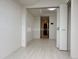 アーバンパーク日暮里2 明るく開放的なリビングダイニング、奥に玄関へ続く廊下が見える