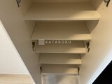 ドゥーエ曳舟3 壁面に取り付けられた複数段の白い棚板が整然と並ぶ収納スペース