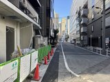 コンフォリア・リヴ茅場町 建設中の現場を示す緑色の仮設フェンスと赤いコーン